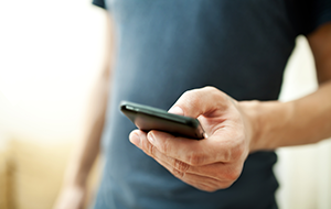 Close-up of man’s hand holding smartphone